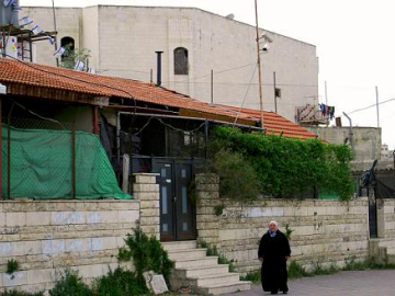 Palestinian woman outside her former home. Her house is now inhabited by Israeli settlers after its Palestinian inhabitants were evicted.